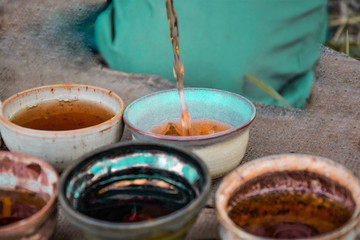pours tea into handmade bowls