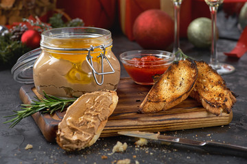 Chicken liver pate in jar and on bread, selective focus