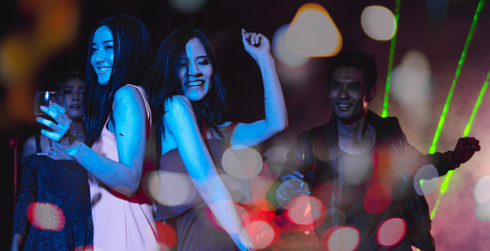 Holiday travel celebrations concept, group of people dancing together with enjoying at colourful night party club.	