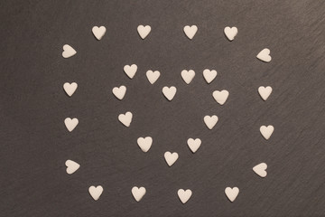 Corazones blancos sobre fondo negro de pizarra