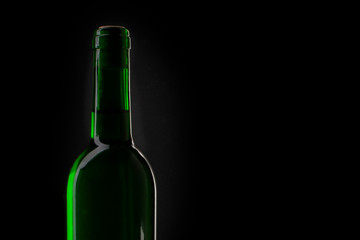Wine green bottle silhouette. Closeup of an opening of a wine bottle with cork in front of black background with text field. There is a place for text.