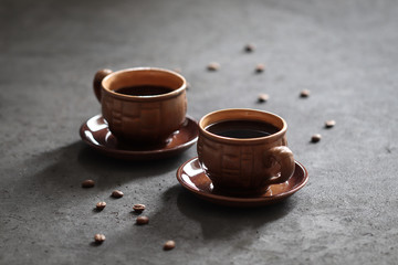 Still life black coffee in a Cup with coffee beans on a dark background