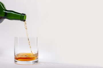 Close-up of an elegant glass for spirits, with a spilled liquor, similar to rum or whiskey, on a...