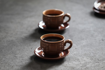 Still life black coffee in a Cup with coffee beans on a dark background