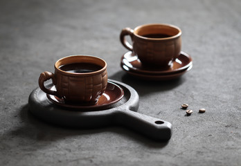 Still life black coffee in a Cup with coffee beans on a dark background