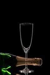 Butelka szampana z kieliszkiem na czarnym tle