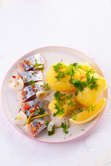 pieces of salted herring in spices with boiled potatoes