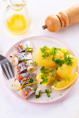 pieces of salted herring in spices with boiled potatoes