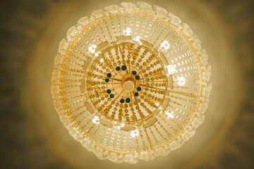 Vintage chandelier on the ceiling of the room in pastel colors. Bottom view.