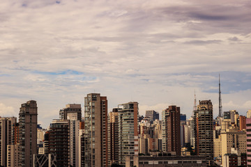 Skyline da cidade de São Paulo, com destaque para zona sul, prédios e céu parcialmente nublado.