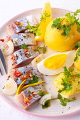 pieces of salted herring in spices with boiled potatoes
