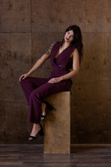 Fototapeta premium Beautiful young woman wearing marsala jumpsuit