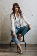 Beautiful young woman wearing white blazer and blue jeans