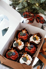 Christmas cupcakes for New Year's decoration. Set of pastries decorated with berries, stars and spruce branches.