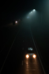 Fogy night on road and lights of cars