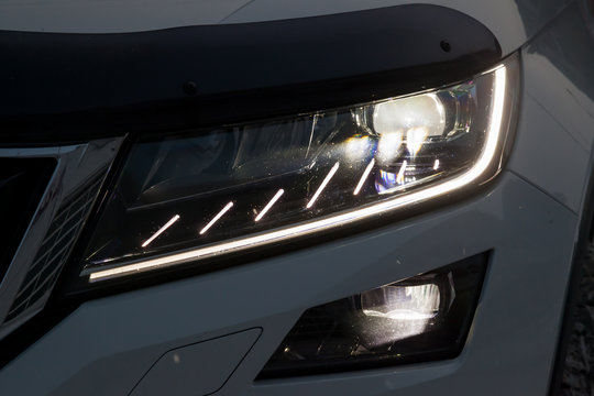 Front Headlamp View Of White Car With  Turn On Led Day Running DRL Light And Bi-xenon Lens