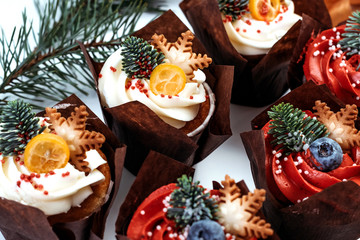 Christmas cupcakes for New Year's decoration. Set of pastries decorated with berries, stars and spruce branches.