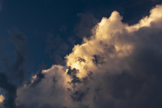 gray Cumulus clouds in a blue sky with orange light © andRiU