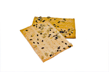 cracker with sesame seeds, flax seeds and sunflower on a white background close-up, isolate