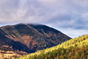 Naklejka premium Cima de una montaña tapada de nubes