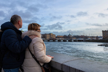 Man and woman in a good mood, looking at the sea and the city. A beautiful evening in Europ