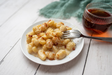 Cheese gnocchi with cheese sauce and bacon bits for garnish on top
