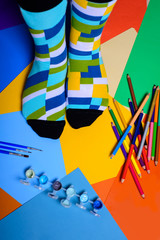 Colorful socks  over bright background with paint and pencils. 