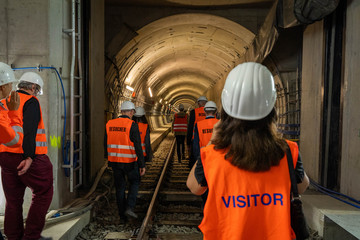 Construction site of a new subway, visitors in foreground