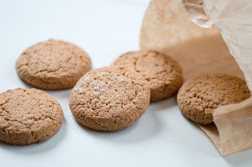 Cookies  skattered on white surface from paper buying bag
