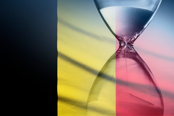 Flag of Belgium with superimposed hourglass conceptual of deadlines
