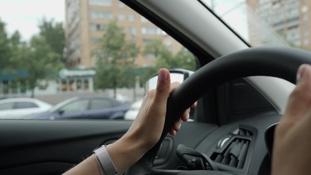 Close up of driver's hands. Woman tap the rythm with fingers on steering wheel