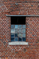 Fototapeta na wymiar Rote Backsteinwand mit altem Fenster als Hintergrund oder Textur