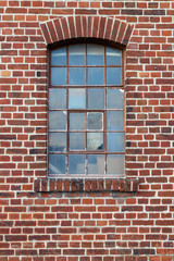 Rote Backsteinwand mit altem Fenster als Hintergrund oder Textur