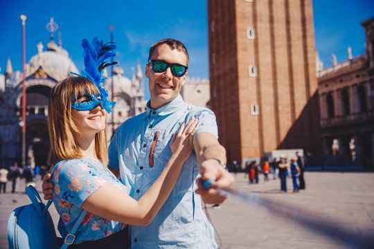 Selfie Lover Couple Taking Photo Travel Venice, Italy Against Backdrop St Mark Square In Blue Venetian Mask