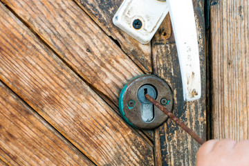 old wooden door with an internal lock that they are trying to crack.