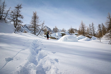 Fototapeta na wymiar Winter landscape with mountaineer tracks in the sunshine, italian Alps