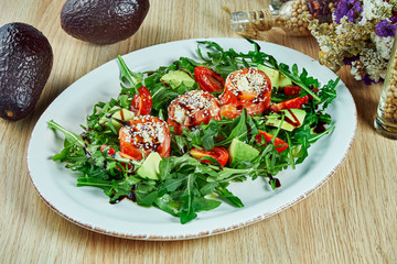 Salted salmon salad arugula on a blue plate on a wooden background. Delicious and healthy breakfast food. Close up