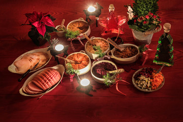 Finnish traditional Christmas table.potato, carrot, chestnut, red cabbage and liver casserole, ham, pulled beef, salmon, salad with carrot, beet,cucumber, apple,lingonberry puree.Top view.Rustic style