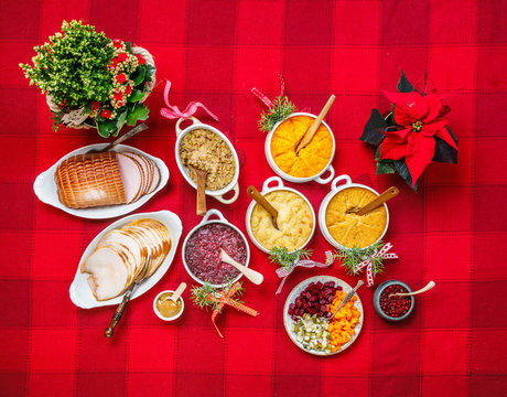 Finnish traditional Christmas table.potato, carrot, chestnut, red cabbage and liver casserole, ham, pulled beef, salmon, salad with carrot, beet,cucumber, apple,lingonberry puree.Top view.Rustic style