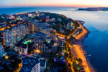 Evening panorama of the seaside resort of Gelendzhik. View of the Thick Cape and lighthouse. See the beach and the promenade. On the left is a large residential complex