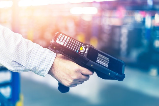 Modern warehouse management. Hand terminal for logistics. Scanning barcode.