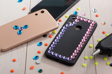 Phone cases being decorated with various rhinestones