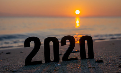 word 2020 on the beach at sunrise
