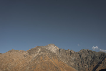 A panoramic view of Mount Kazbegi is a sleeping stratovolcano and one of the main mountains of the Caucasus, located on the border of the Kazbegi region of Georgia. In lush lava color. Design and crea