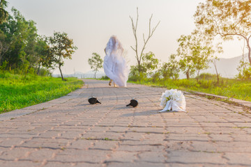 Beautiful bride wearing a white wedding dress running away alone