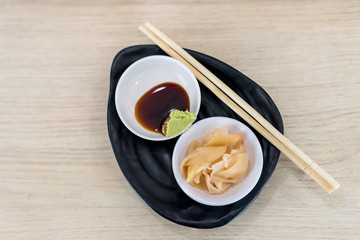 Ginger and wasabi on plate. traditional Japanese condiments - wasabi, ginger and soy sauce - a set for sushi on table. Pickled ginger with soy sauce and wasabi for sushi.