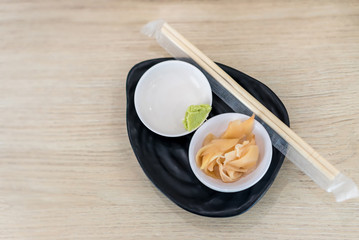 Ginger and wasabi on plate. traditional Japanese condiments - wasabi, ginger and soy sauce - a set for sushi on table. Pickled ginger with soy sauce and wasabi for sushi.