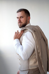 Male model in white shirt and red tie, black jacket and trousers, athletic build, isolated on a white background. The concept of classic clothes or office style.