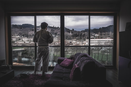 Karateca olhando pela janela para a cidade