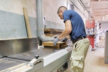 Male carpenter making wooden designer furniture for an individual private order